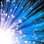 right burst of light with blue and white fiber optic strands representing the future of AI, high-speed data transmission, AI-driven technology advancements, and the potential of artificial intelligence in innovation and automation.