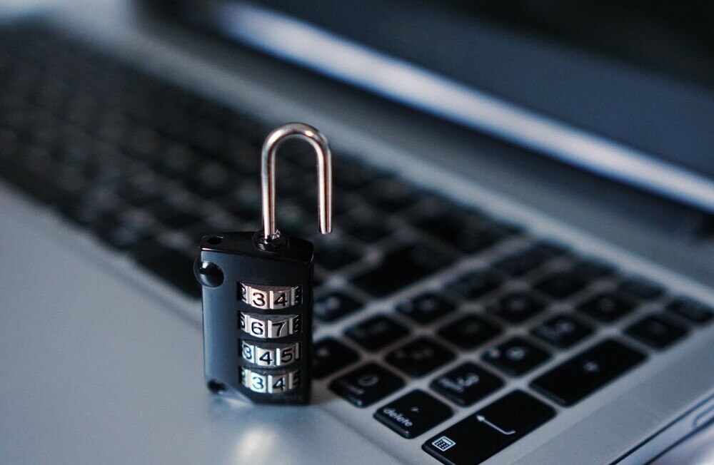 An open padlock on a laptop keyboard, representing online privacy, cybersecurity, and securing personal data